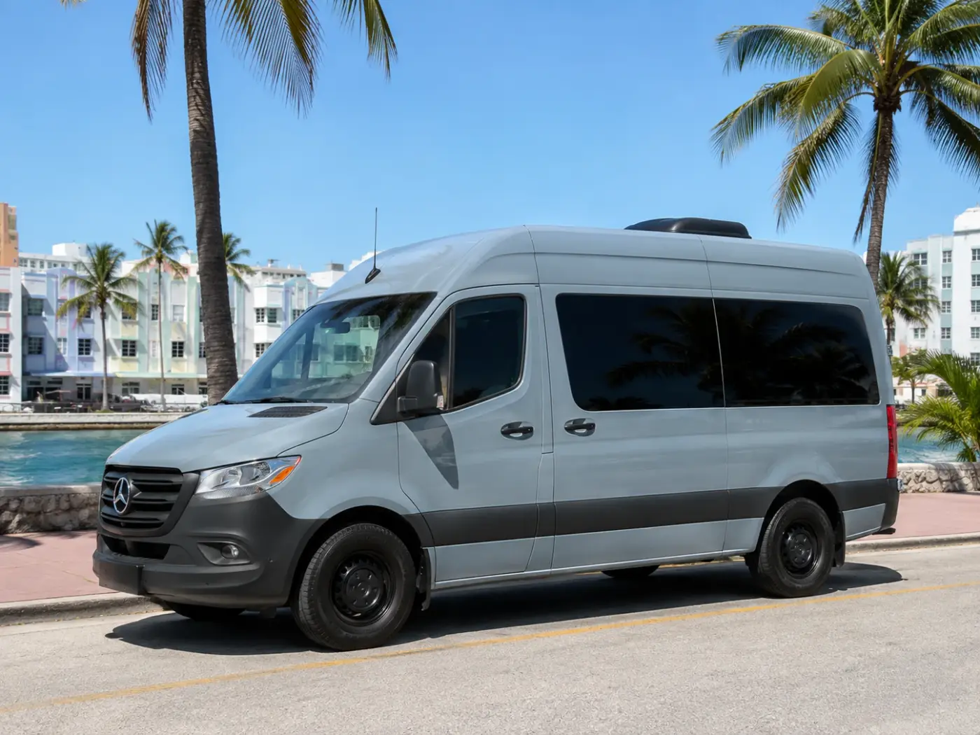 The VanVenture MIA van parked under palm trees on Ocean Drive